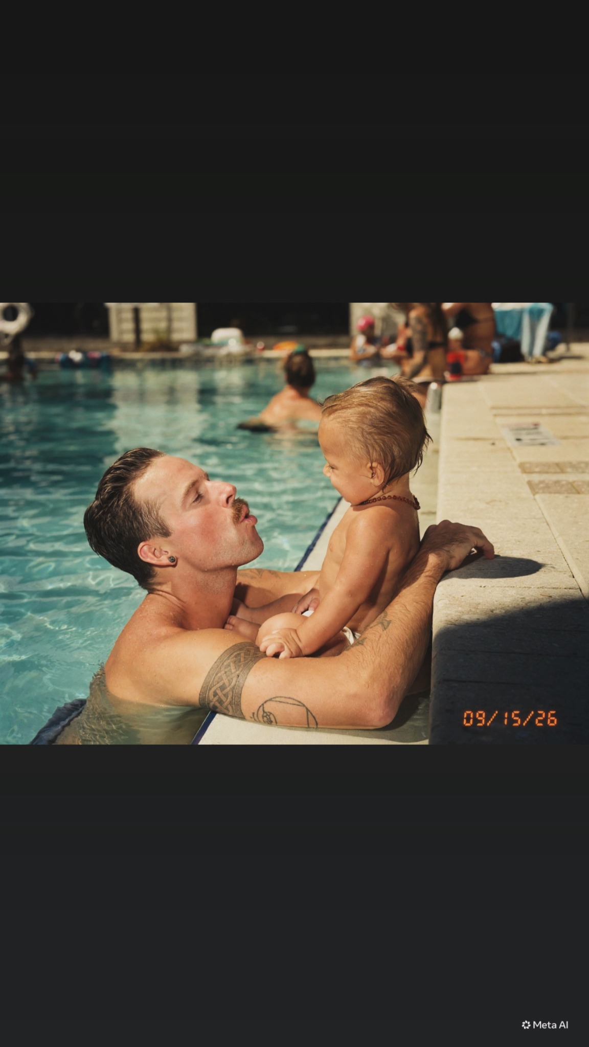 Nick sharing a poolside moment with his son